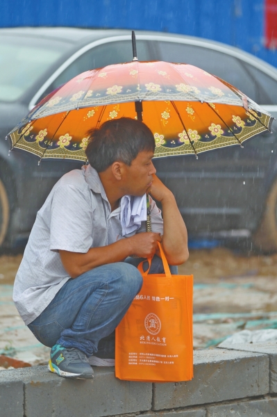 冒雨守在考点门外牵肠挂肚的家长