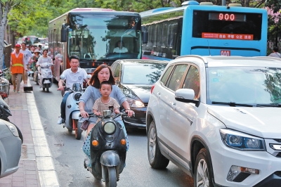 经二路拥堵，非机动车只得在间缝中穿行。