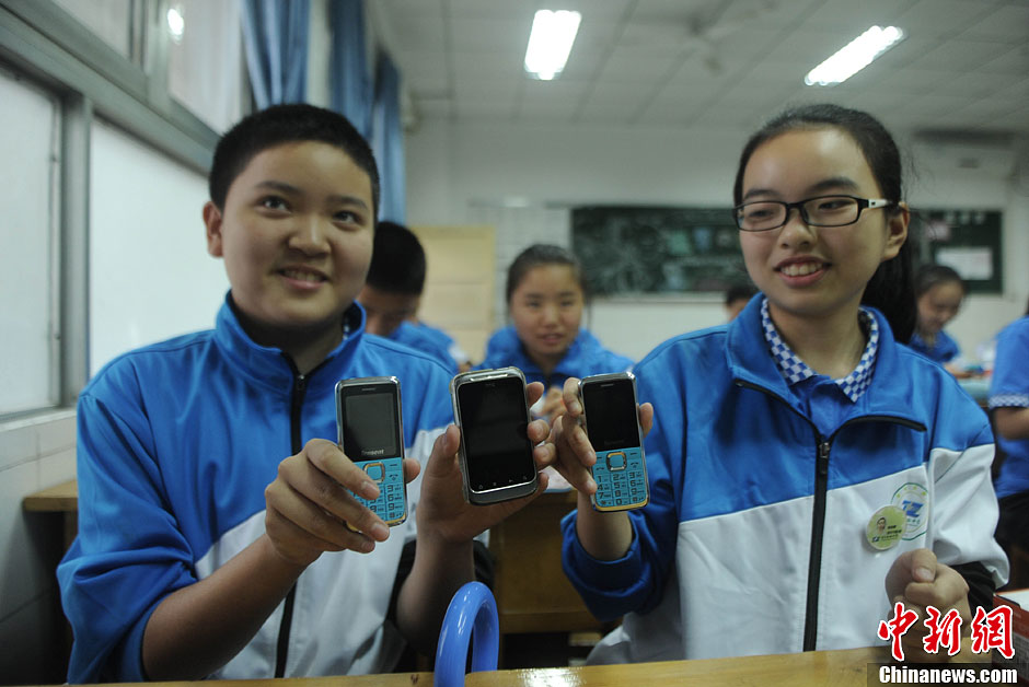 图为同学领取了非智能手机和自己的智能手机作对比。