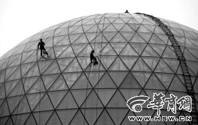 昨日下午3时,西安市长安南路,陕西自然博物馆球形玻璃外立面上,工人正在雾霾中施工。污染天气下,户外工作时,要做好防护措施 本报记者 黄利健 摄