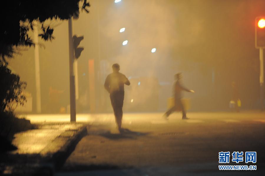 12月5日清晨，行人在雾霾笼罩的合肥市街头行走。