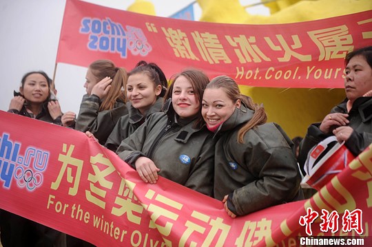 图为重庆市民和外国友人一同举着“为冬奥运动健儿加油”标语。