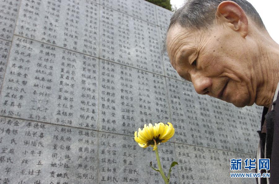 2006年4月5日，74岁的南京大屠杀幸存者佘子清手捧鲜花，祭奠被日军杀害的母亲。