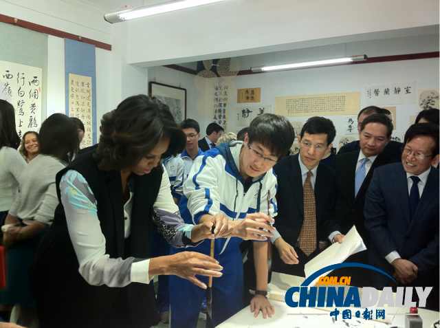 北京时间3月21日，美国第一夫人米歇尔参观北师大二附中时，与学生一起练习书法。