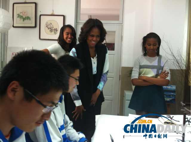 　北京时间3月21日，美国第一夫人米歇尔参观北师大二附中时，与学生一起练习书法。
