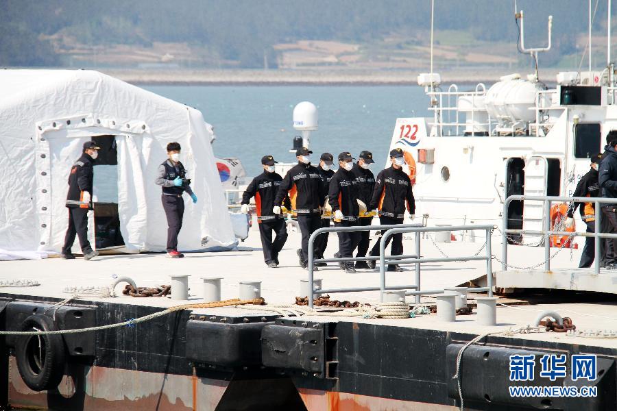 4月22日，在韩国珍岛彭木港，警务人员护送遇难者遗体下船。