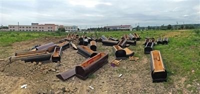 40多副棺木被砸坏后，扔在荒地上。