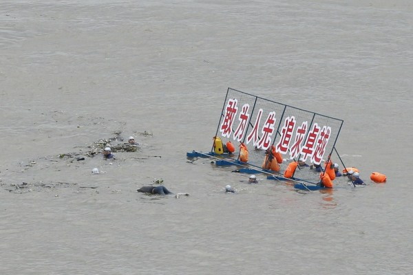 7月16日，武汉渡江节，一具从上游漂流而下的浮尸冲进横渡队伍，横渡队员措手不及。牛森/东方IC