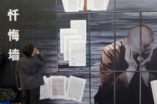 2011年10月8日，“杭州市反腐倡廉成果展览”，观众在观看一面忏悔墙上犯案人员的忏悔书。