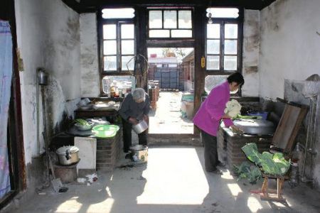 其母用大锅灶生火做饭招待