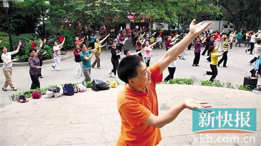 一名舞蹈老师正在带领前来晨练的市民跳舞。