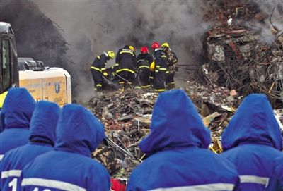 1月3日，哈尔滨大火现场，消防员在倒塌的楼体中进行搜救。