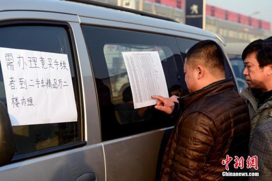 1月23日，北京亚运村汽车交易市场中拓拍卖停车场上人头攒动，市民查看拍卖车辆信息。