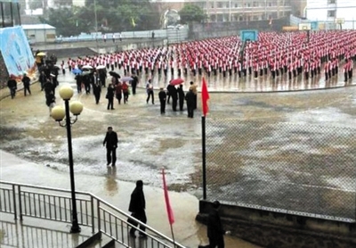 近日，网传广西玉林市容县一中学“学生冒雨做操，领导打伞欣赏”的照片，引发争议。