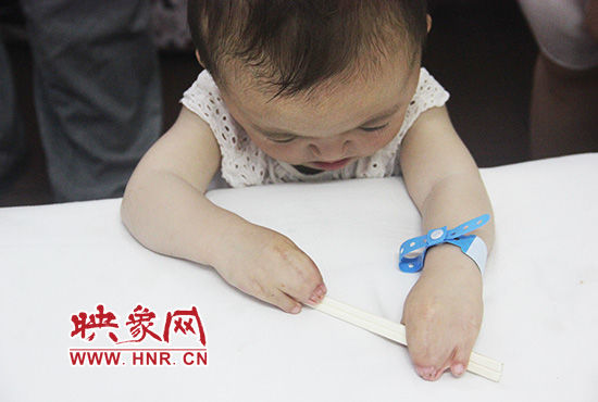 孩子握着筷子发呆。