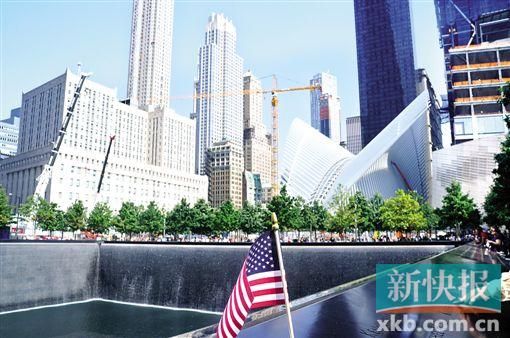 “9·11”遗址,,一名男子指着水池边上的名字对身旁的孩子说,“这些人都是英雄。”