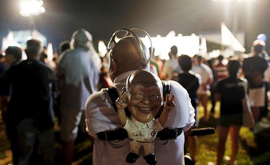 9月4日，新加坡，执政党的一场集会上，一名支持者背着一个李光耀的人偶。