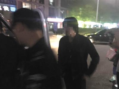 昨晚，在宋冬野经营的“NOTHERE不在”酒吧，警方带走一名戴口罩的长发女子及酒吧工作人员。 新京报记者 林斐然 摄