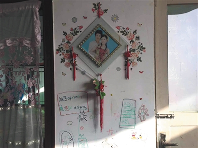 11月27日，河北白范疃村，白海朋夫妻合影下是女儿涂鸦。新京报记者 赵蕾 摄