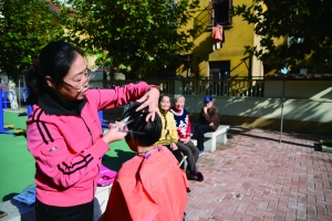 高美英在社区为老人剪头发 张哲仁 摄
