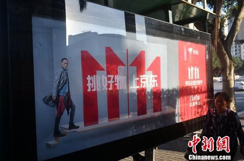 资料图：11月1日，福州民众从双十一广告牌前经过。中新社记者 吕明 摄