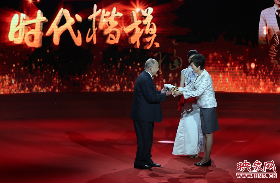 河南邓州“编外雷锋团”团长宋清梅接受“时代楷模”发布厅赠送的楹联。