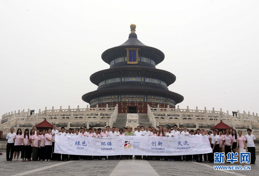 李克强同默克尔与青少年在天坛祈年殿前合影留念。