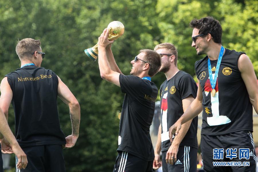 7月15日，德国队球员拉姆（左二）展示大力神杯。