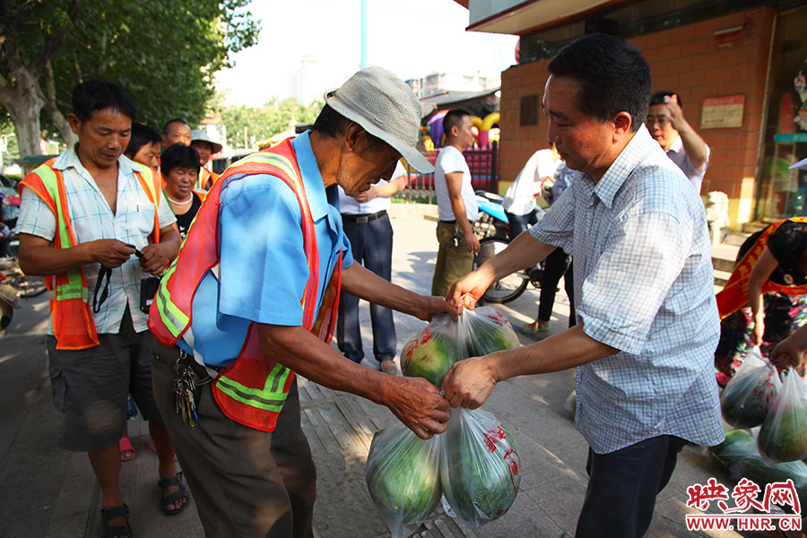 郑州市供销合作社主任刘五一在现场给环卫工人发放西瓜。