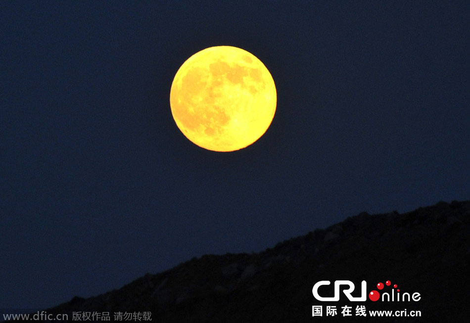 8月10日晚，一轮金灿灿的大月亮在辽宁省大连市东方升起。图片来源：刘德斌/东方IC