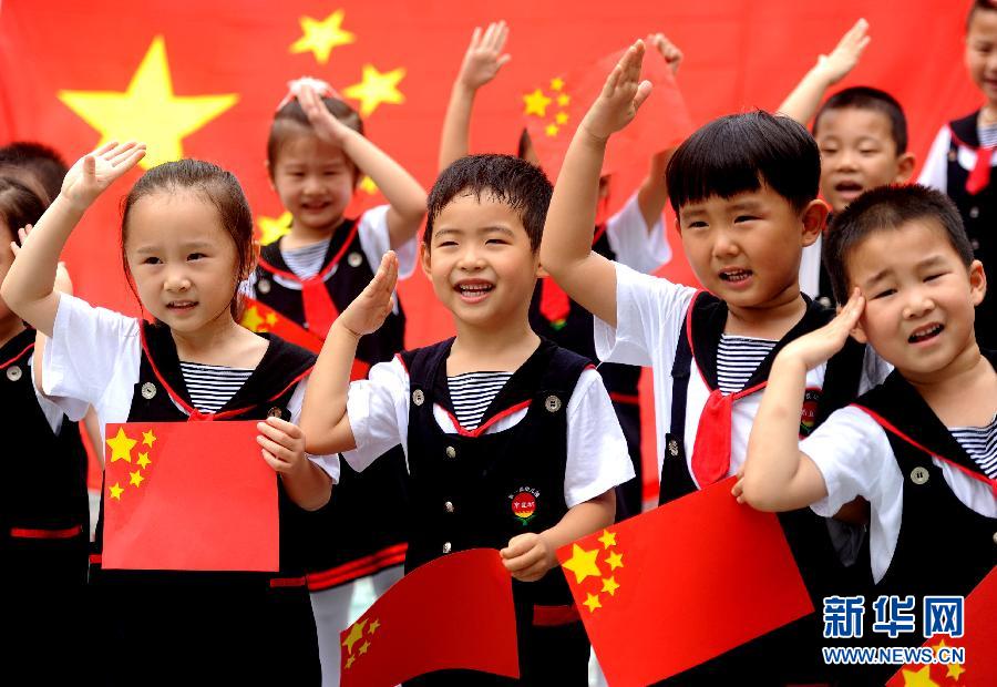  9月28日，安徽淮南市直机关幼儿园的小朋友在国旗前唱《国歌》，庆祝祖国65周岁生日。