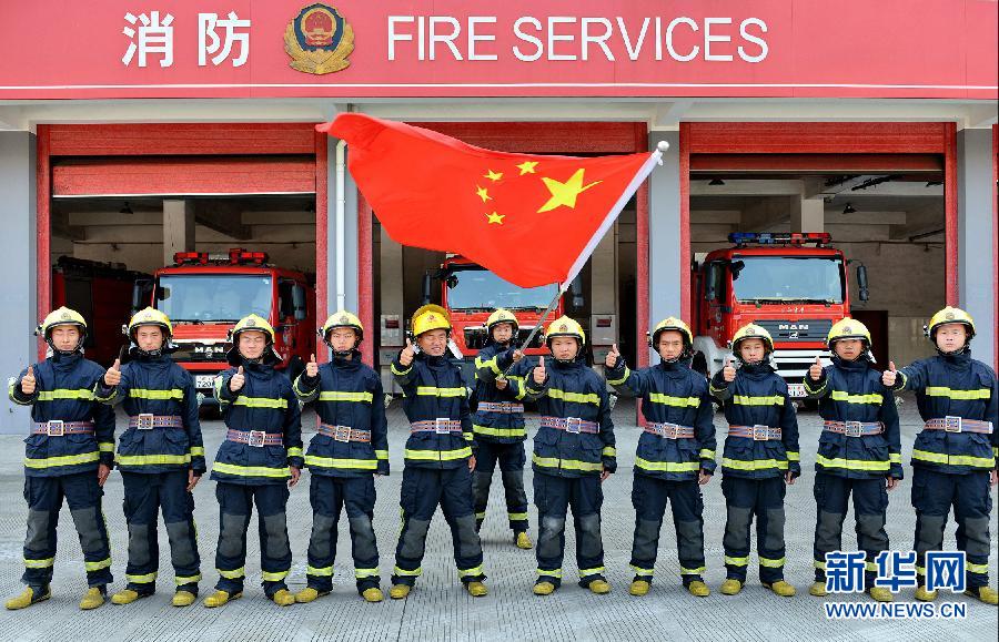  9月25日，武警浙江嘉兴消防官兵与国旗合影。