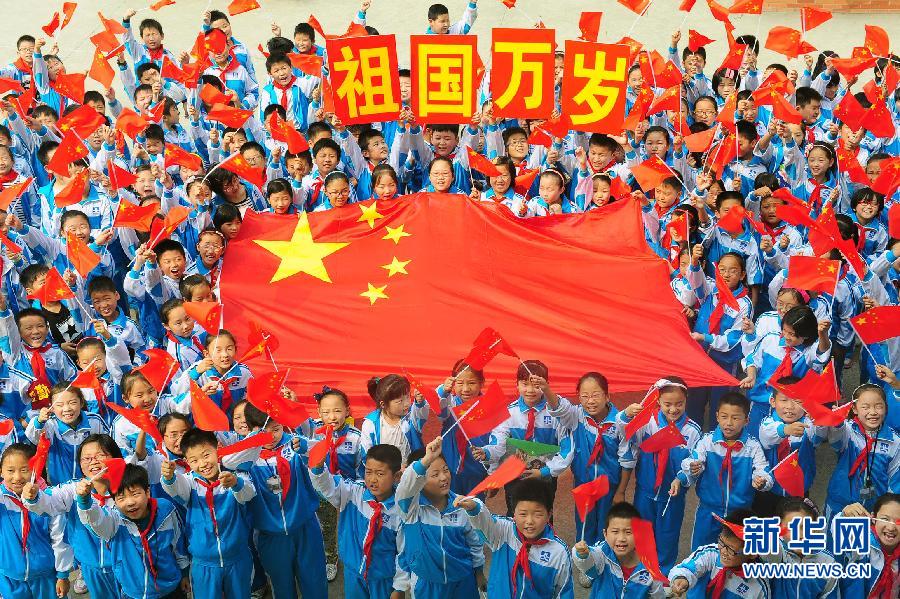 9月26日，安徽省阜阳市北城小学分校的学生与国旗合影。