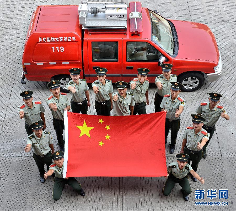  9月25日，武警浙江嘉兴消防官兵与国旗合影。