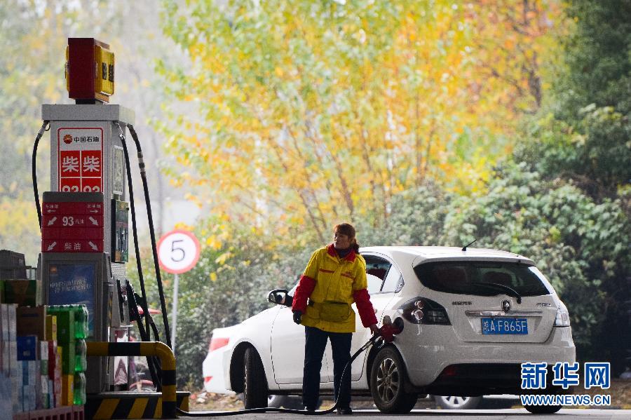  11月28日，安徽省合肥市一家加油站的工作人员在为汽车加油。