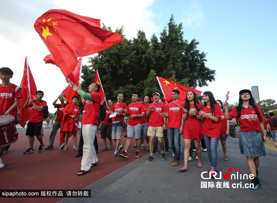 赛前中国球迷挥舞国旗进场，为国足助威。