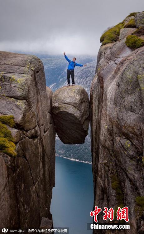 挪威游客冒雨登上千米高悬石拍照