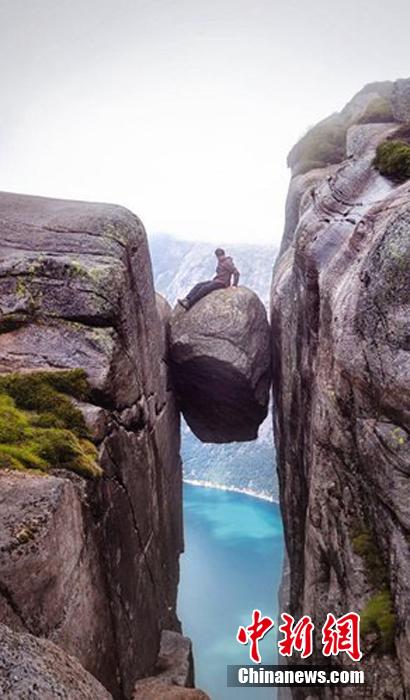挪威游客冒雨登上千米高悬石拍照