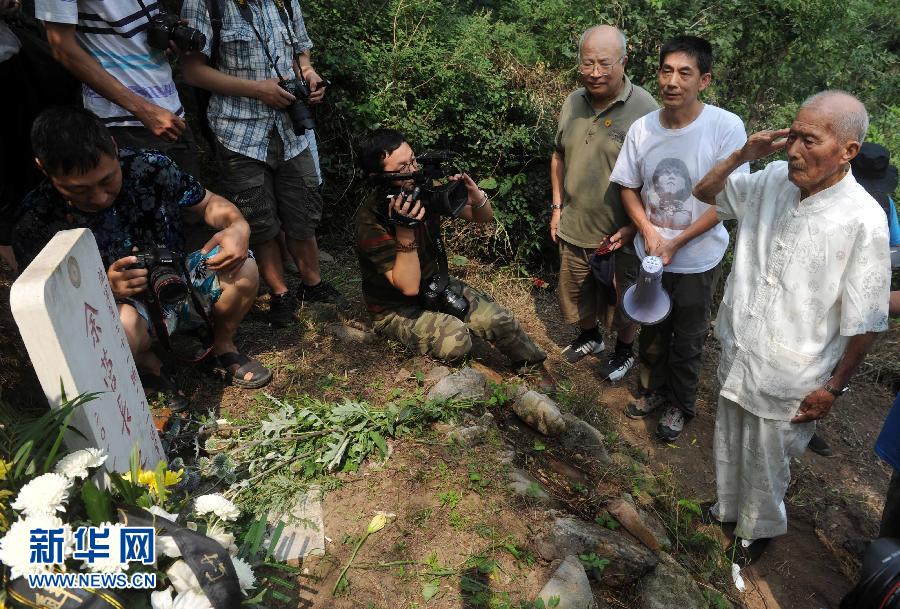 97岁的抗战老兵贾善明（右一）在北京昌平南口镇羊台子村，向当年牺牲并长眠于此的营长余恩涛的墓碑敬礼