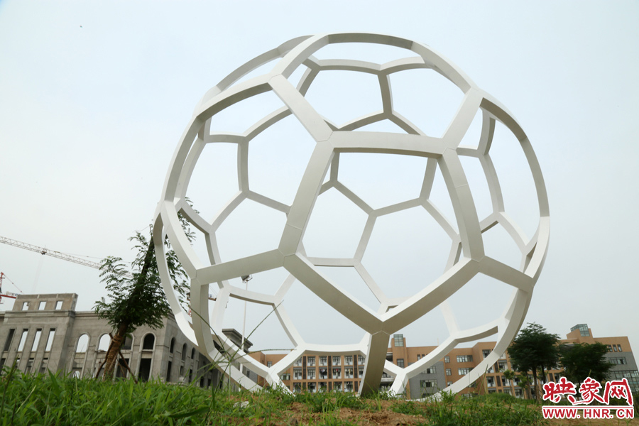 这座多方体雕塑酷似“足球”，在河南农业大学龙子湖校区的操场旁边，。