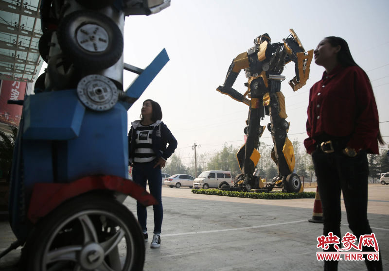 10月14日，市民在参观河南省平顶山市宝丰县一家企业门前的“变形金刚”。