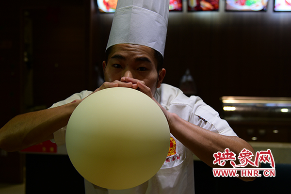 郑州大厨师现场表演吹面团气球。