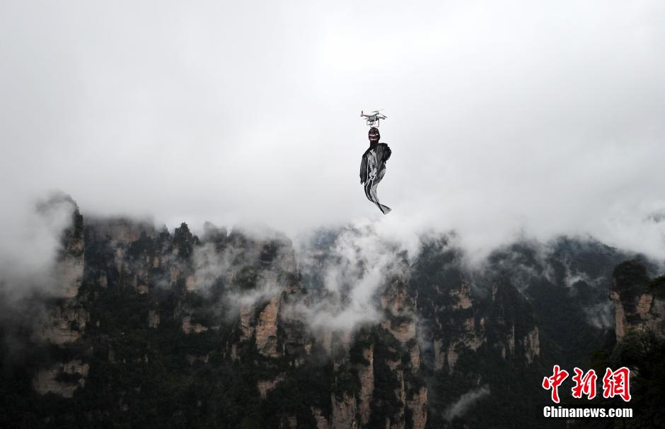 5名来自西安的大学生来到湖南张家界武陵源百龙天梯景区为游客们上演了一场“万圣空中幽灵秀”。