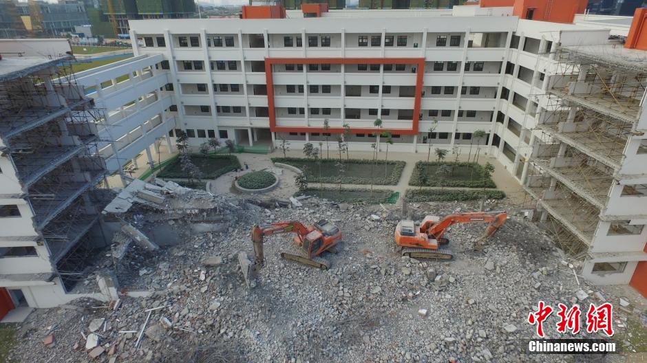 1月4日下午，广西南宁天桃实验学校荣和校区，两台大型破拆机械在拆除教学楼。