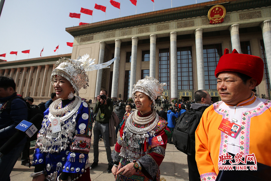贵州代表团的银头饰（左一）和湖南代表团代表的头饰和帽子