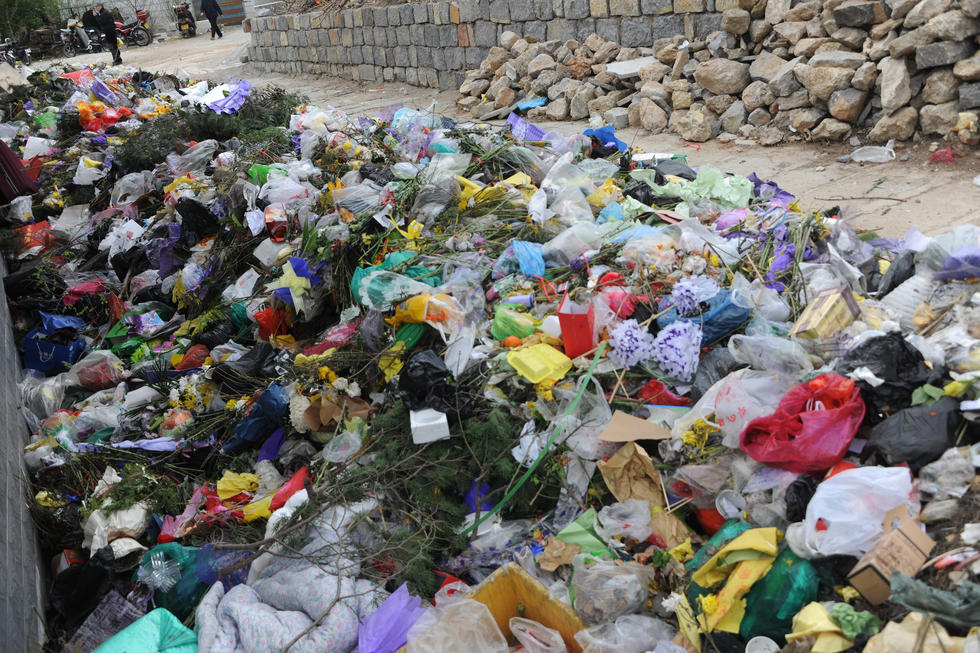 济南公墓垃圾堆积如山 工人每天背4000斤