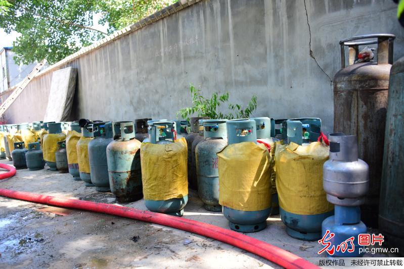 郑州一非法液化气灌装点爆炸 消防员火中抢出近百液化罐