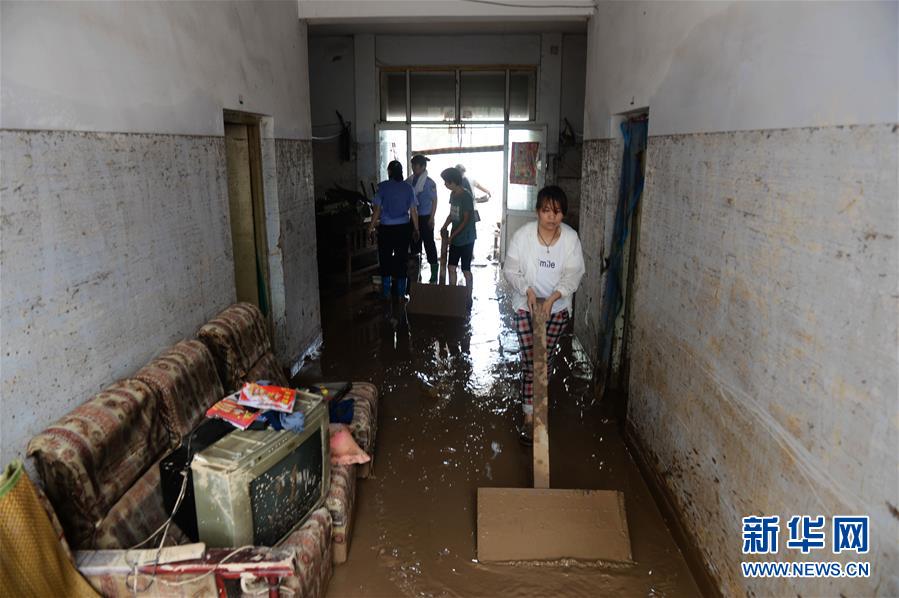 7月24日，邢台市南市屯村村民在家中清理淤泥。