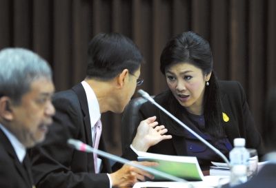 1月15日，在泰国曼谷，泰国看守政府总理英拉右一在研讨会上与参会者交谈。新华社发