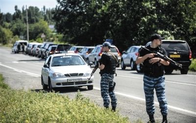 　7月28日，来自澳大利亚和荷兰的调查人员前往坠机现场途中，乌克兰民间组织在其车队后面封锁道路。
